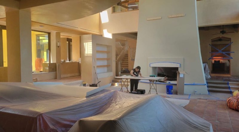 Wallpaper install in progress in a bright, high-ceilinged living room